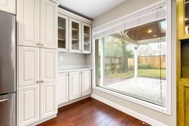 entryway with baseboards and dark wood-style flooring