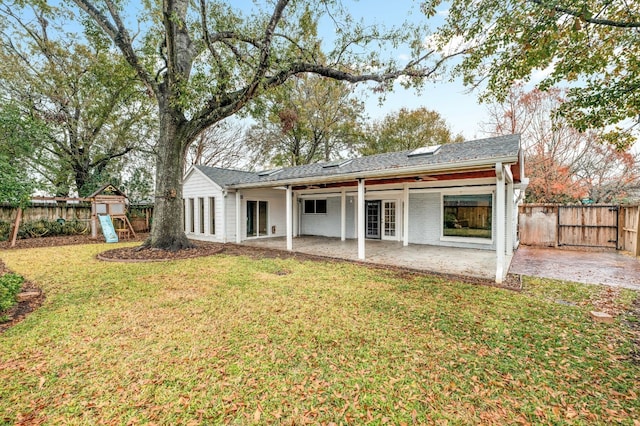 rear view of house featuring a yard, a playground, and a patio area