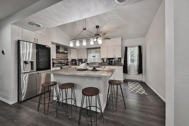 kitchen with decorative backsplash, appliances with stainless steel finishes, white cabinets, and decorative light fixtures