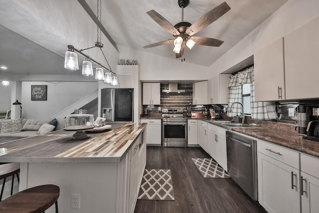 kitchen featuring stainless steel appliances, a kitchen breakfast bar, hanging light fixtures, and white cabinets