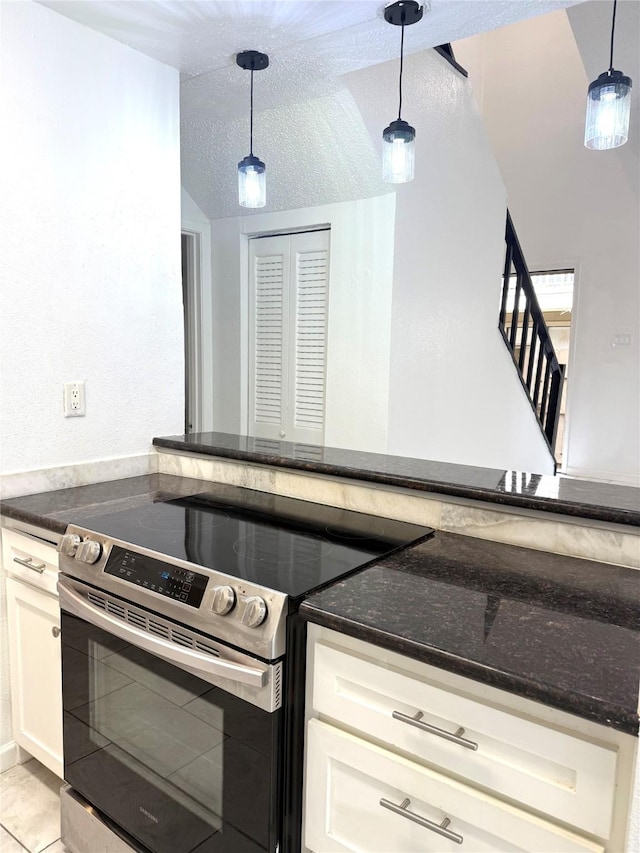 kitchen featuring stainless steel electric stove, lofted ceiling, a textured ceiling, and decorative light fixtures