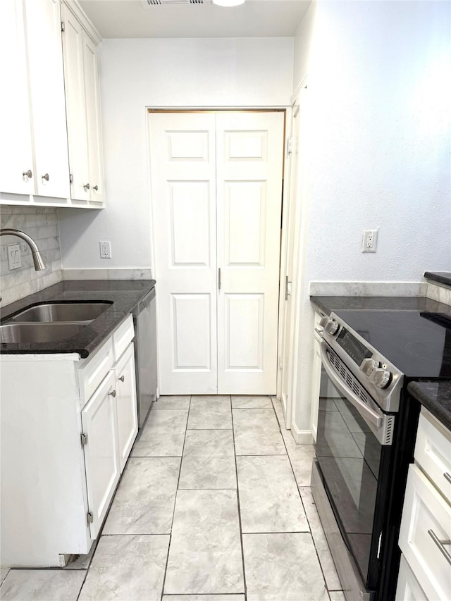 kitchen featuring backsplash, appliances with stainless steel finishes, sink, and white cabinets