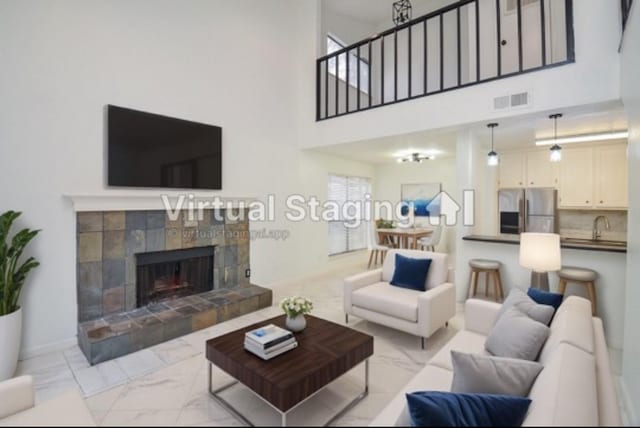 living room featuring marble finish floor, baseboards, a fireplace, and visible vents