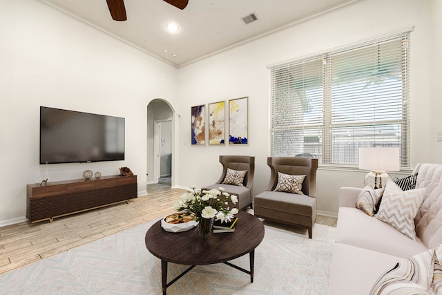 living room featuring crown molding, light hardwood / wood-style flooring, and ceiling fan