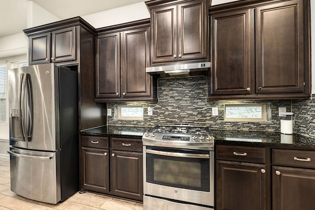 kitchen with appliances with stainless steel finishes, decorative backsplash, dark brown cabinetry, and dark stone counters