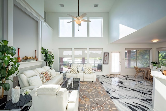 living room with plenty of natural light, a towering ceiling, and ceiling fan