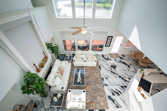 living room featuring a towering ceiling and ceiling fan