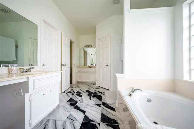 bathroom with vanity and a relaxing tiled tub