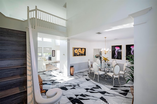 interior space featuring crown molding, a towering ceiling, and an inviting chandelier