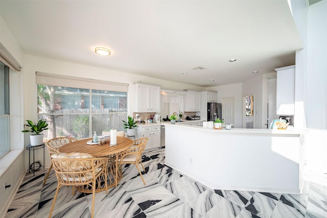 kitchen featuring white cabinetry and stainless steel fridge