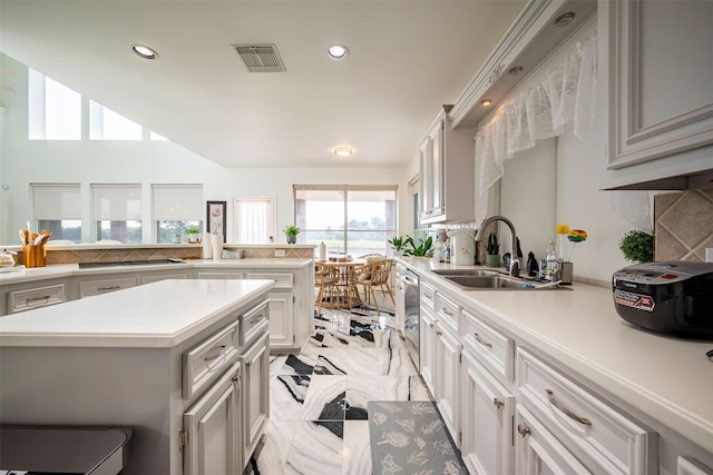 kitchen featuring backsplash, stainless steel dishwasher, sink, and white cabinets