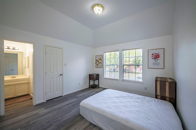 bedroom featuring dark hardwood / wood-style flooring, sink, vaulted ceiling, and ensuite bathroom