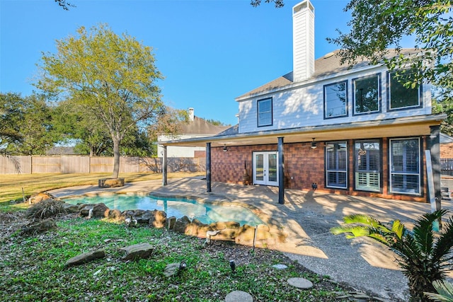 back of house with a fenced in pool, a patio area, and french doors