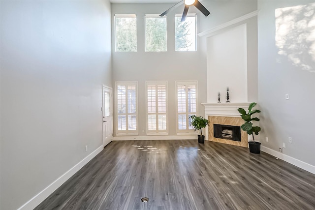 living room featuring a high ceiling, a premium fireplace, plenty of natural light, and dark hardwood / wood-style floors