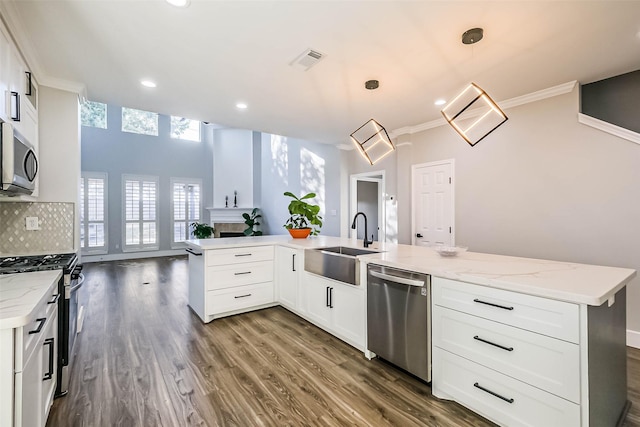 kitchen with sink, decorative light fixtures, white cabinets, and appliances with stainless steel finishes