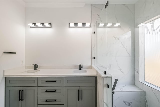 bathroom featuring a shower with door and vanity