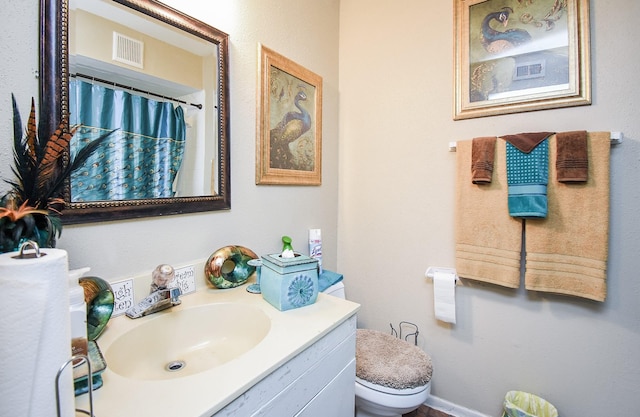 bathroom featuring a shower with curtain, vanity, and toilet