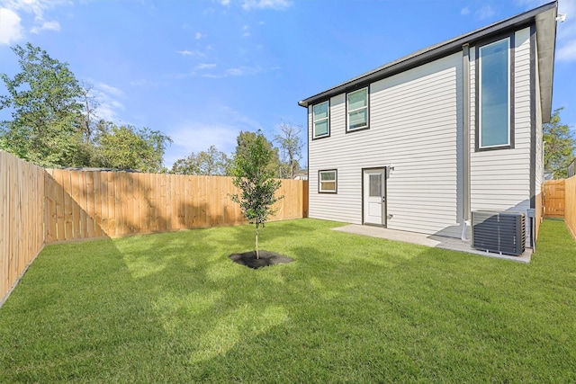 rear view of property with a patio, a yard, and cooling unit