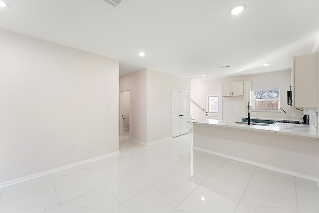 kitchen featuring white cabinetry, light stone countertops, sink, and stove