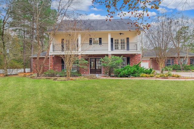 view of front facade featuring french doors, a balcony, and a front lawn