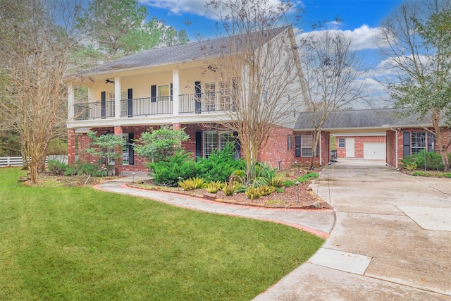 view of front of property with a garage, a balcony, and a front lawn