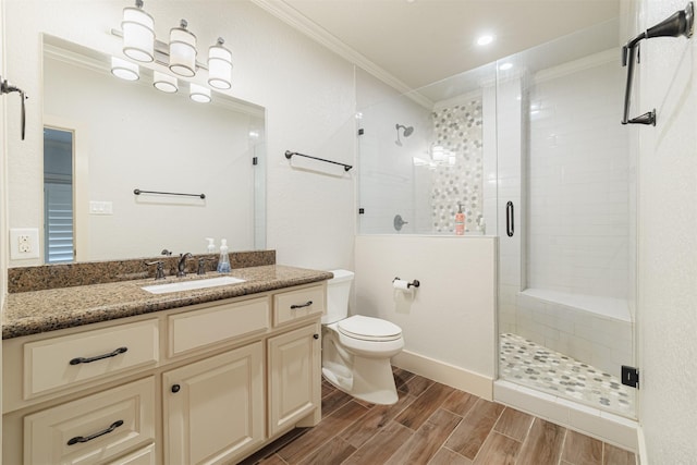 bathroom featuring crown molding, vanity, toilet, and an enclosed shower