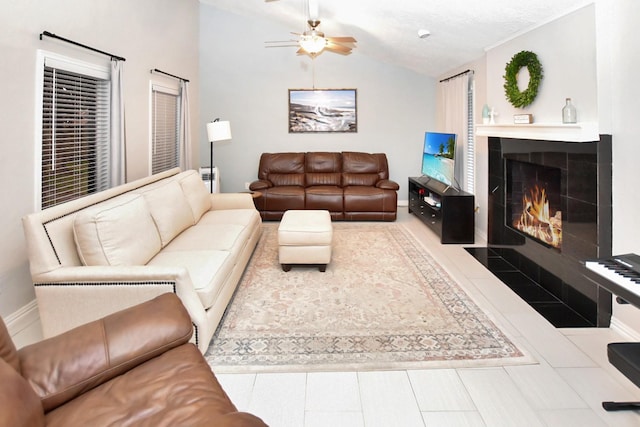 living room with tile patterned floors, lofted ceiling, a textured ceiling, a tile fireplace, and ceiling fan