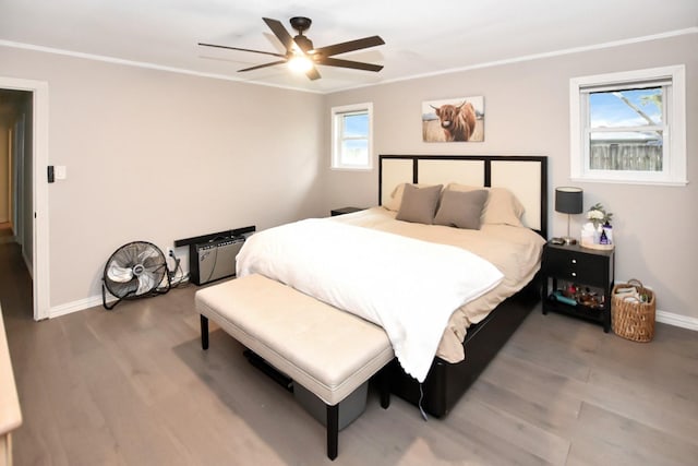 bedroom featuring hardwood / wood-style floors, ornamental molding, and ceiling fan