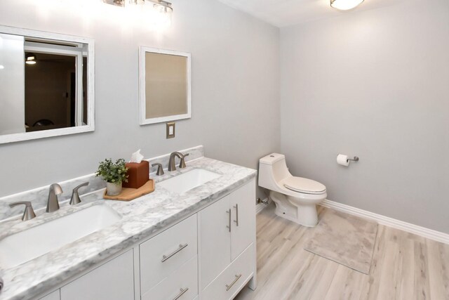 bathroom with hardwood / wood-style flooring, vanity, and toilet