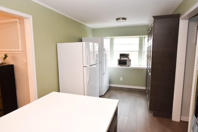 kitchen featuring hardwood / wood-style flooring, crown molding, white fridge, and dark brown cabinetry