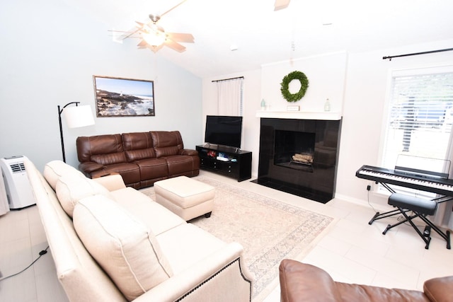 living room with ceiling fan, lofted ceiling, and a tiled fireplace