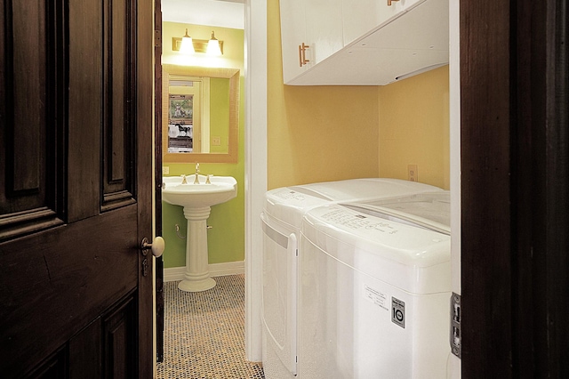 laundry room featuring cabinets, washer and dryer, and tile patterned flooring