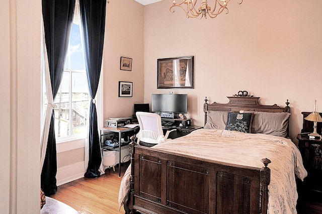 bedroom with an inviting chandelier and light hardwood / wood-style flooring