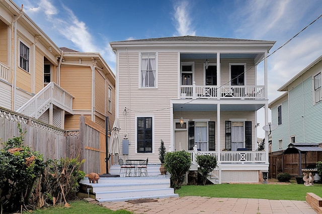 view of front of home with a front lawn, a patio, and a balcony