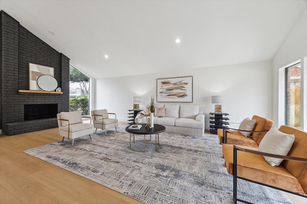 living room featuring lofted ceiling, hardwood / wood-style floors, and a wealth of natural light