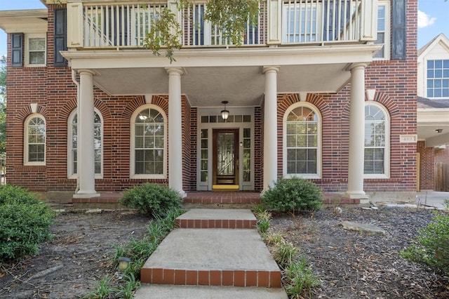 entrance to property featuring a balcony and a porch