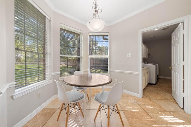 dining room with crown molding, washer and dryer, and light tile patterned floors