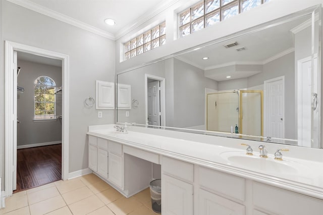 bathroom featuring walk in shower, vanity, crown molding, and tile patterned flooring