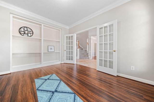 interior space featuring french doors, ornamental molding, built in shelves, and hardwood / wood-style floors