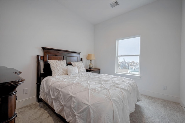 bedroom with lofted ceiling and light carpet