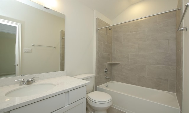 full bathroom with tiled shower / bath, lofted ceiling, vanity, and toilet