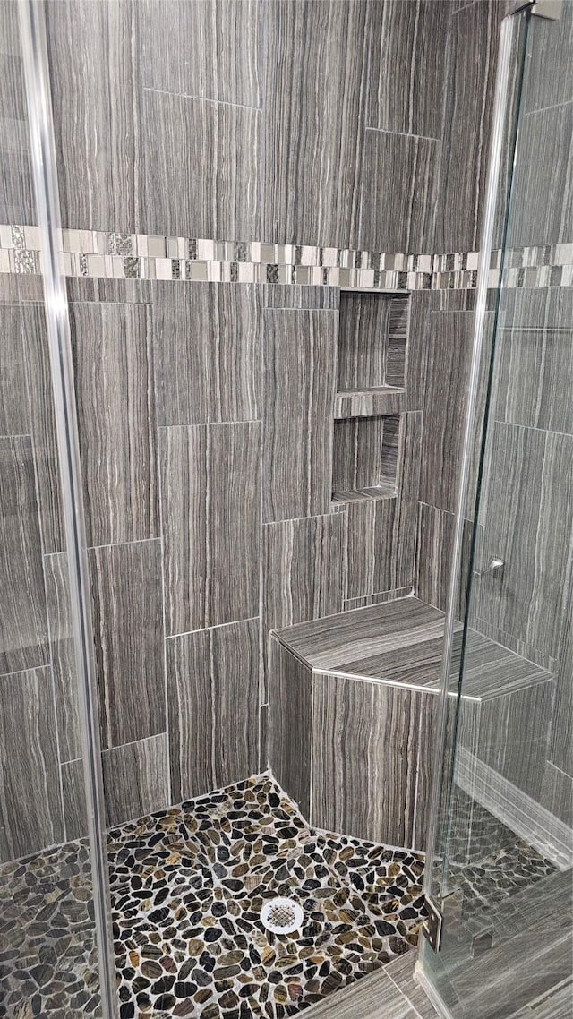 bathroom featuring a shower with door