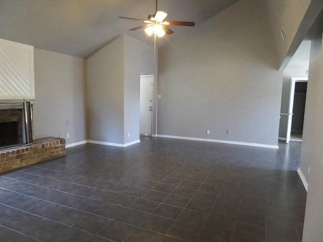 unfurnished living room with ceiling fan, a fireplace, high vaulted ceiling, and dark tile patterned floors