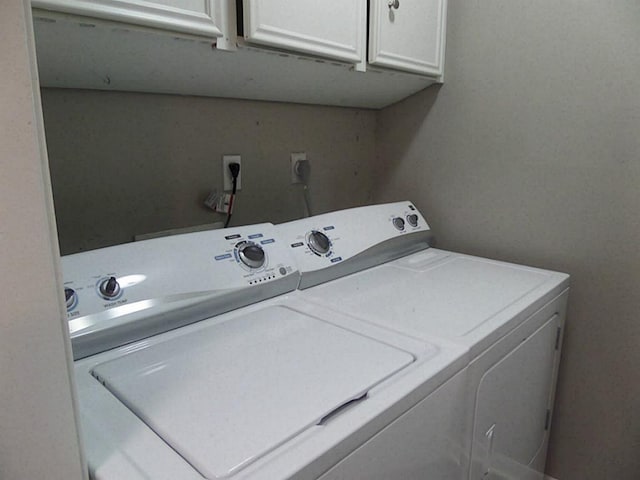 laundry room with independent washer and dryer and cabinets