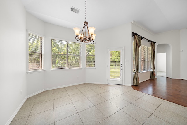 unfurnished room featuring light tile patterned floors and a chandelier