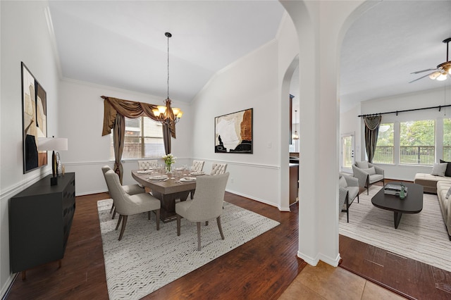 dining room with dark hardwood / wood-style flooring, ceiling fan with notable chandelier, vaulted ceiling, and ornamental molding