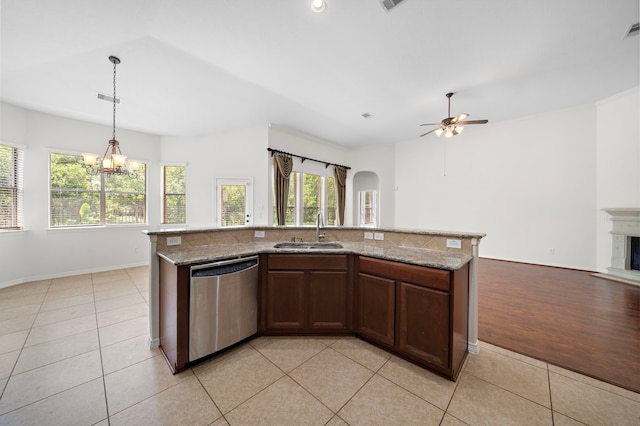 kitchen with sink, dishwasher, light stone counters, a center island with sink, and decorative light fixtures