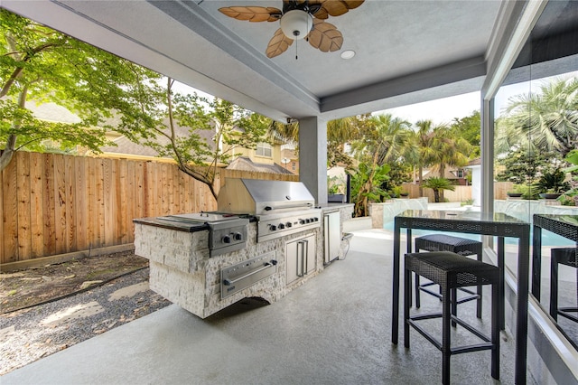 view of patio with ceiling fan, area for grilling, and a grill