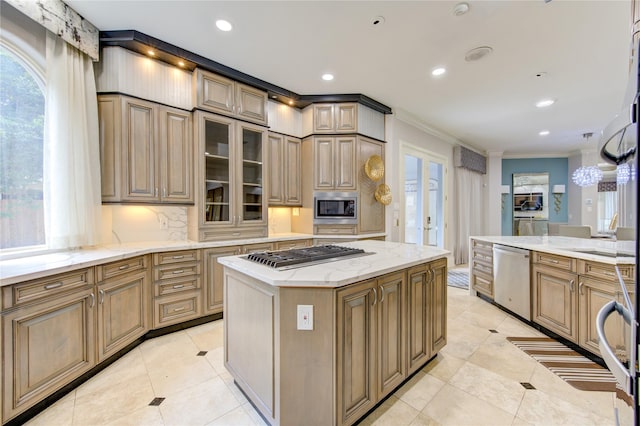 kitchen with a kitchen island, appliances with stainless steel finishes, ornamental molding, plenty of natural light, and french doors