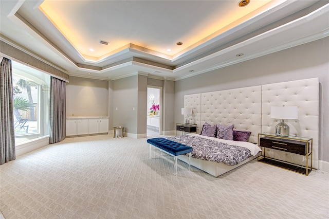 bedroom with a raised ceiling, ornamental molding, and carpet